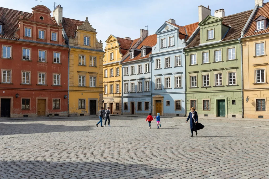 Polish historic city square with rebuilt colourful facades and cobblestones in daylight