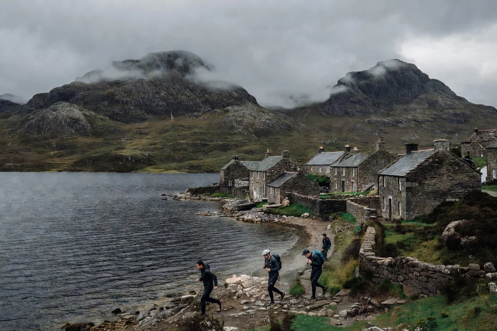 Scottish loch with steep mountains, a stone village and low clouds