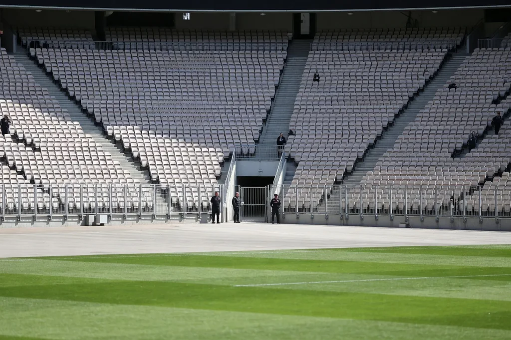 The away supporters' sector in the corner of a football stadium seen from across the pitch