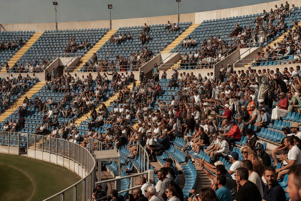 Italian football ground with steep tiered stands and blue seats under Mediterranean sunlight